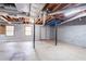 Spacious basement with windows, visible ceiling pipes, brick foundation, and support pillars at 2352 Rockwood Way, Stone Mountain, GA 30087