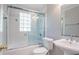 Bright bathroom featuring a tub with glass doors and pedestal sink at 2352 Rockwood Way, Stone Mountain, GA 30087