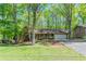 Charming one story brick home featuring a two car garage, covered front porch, and mature trees at 2352 Rockwood Way, Stone Mountain, GA 30087
