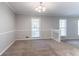 Light-filled living room features neutral paint, plush carpet and staircase access at 2352 Rockwood Way, Stone Mountain, GA 30087