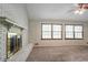 Cozy living room featuring a brick fireplace, plush carpet, and large windows for natural light at 2352 Rockwood Way, Stone Mountain, GA 30087
