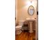 Classic half bathroom with a pedestal sink, decorative mirror, and hardwood flooring at 9989 Village South Dr, Douglasville, GA 30135