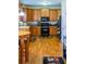 Well-equipped kitchen with wooden cabinets, black appliances, and hardwood flooring at 9989 Village South Dr, Douglasville, GA 30135