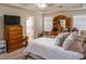 Cozy main bedroom with tray ceilings, fan, plush carpets, and a dresser with TV at 9989 Village South Dr, Douglasville, GA 30135