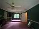 A large living room with views of the backyard, featuring green walls, purple carpet, and large windows at 3798 Lee Ridge Sw Way, Lilburn, GA 30047