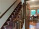Carpeted staircase leading to the second floor with a wood banister and view into the dining room at 3798 Lee Ridge Sw Way, Lilburn, GA 30047