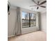 Carpeted bedroom with ceiling fan, a large window with curtains, and neutral-colored walls at 400 17Th Nw St # 2125, Atlanta, GA 30363