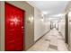 Hallway view of the building interior featuring neutral walls, tile flooring, and bright red apartment door at 400 17Th Nw St # 2125, Atlanta, GA 30363