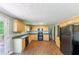 Kitchen featuring wood cabinets, black appliances, wood floors and access to the back deck at 4170 N Quail N Dr, Douglasville, GA 30135