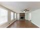 Bright living room featuring a stone fireplace, wood floors, a ceiling fan and natural light at 4170 N Quail N Dr, Douglasville, GA 30135