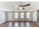 Living room showcasing wood floors, a ceiling fan, a stone fireplace and a white front door at 4170 N Quail N Dr, Douglasville, GA 30135