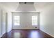 Bedroom with tray ceilings, two windows offering natural light, and dark wood flooring at 101 Valleydale Dr, Stockbridge, GA 30281