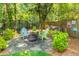 Cozy backyard patio featuring stone, comfortable seating, fire pit and lush landscaping at 1157 Hancock Ne Dr, Atlanta, GA 30306