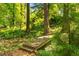 Wood backyard bridge crossing a creek surrounded by lush greenery and serene nature views at 1157 Hancock Ne Dr, Atlanta, GA 30306