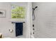 Bright white tiled bathroom with a shower/tub and window at 1157 Hancock Ne Dr, Atlanta, GA 30306