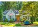 Charming home with a landscaped front yard, mature trees, and inviting front porch with a bench seat at 1157 Hancock Ne Dr, Atlanta, GA 30306