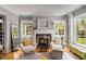 Bright living room features hardwood floors, a decorative fireplace, and two chairs with ottomans by large windows at 1157 Hancock Ne Dr, Atlanta, GA 30306