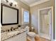 Bright bathroom features a granite countertop, decorative mirror, and a tiled shower with glass door at 125 Stoney Ridge Dr, Alpharetta, GA 30022