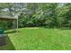 Backyard view of the home shows a grassy area with mature trees and the bottom of the back deck at 1303 Flat Shoals Rd, Atlanta, GA 30349