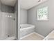 Bright bathroom featuring a shower, soaking tub and a window at 1303 Flat Shoals Rd, Atlanta, GA 30349