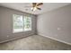 Light-filled bedroom showcases neutral walls, carpet, a ceiling fan, and large window, offering a relaxing ambiance at 1303 Flat Shoals Rd, Atlanta, GA 30349