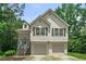 Charming two-story home features a two-car garage, light siding, green trees and neatly landscaped front yard at 1303 Flat Shoals Rd, Atlanta, GA 30349