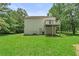 Back exterior view of home features a deck, grassy area, and mature trees at 1303 Flat Shoals Rd, Atlanta, GA 30349