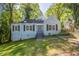 Charming light blue house with black shutters and a well-maintained front yard and mature trees in a quiet neighborhood at 1328 Lockhaven Sw Cir, Atlanta, GA 30311