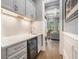 Features a custom wet bar with wine fridge, granite countertop, and stylish white cabinets at 3039 Malbec Vly, Acworth, GA 30101