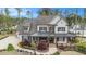 Two-story home boasts a covered front porch, professional landscaping, a mix of painted brick, and stone accents at 3039 Malbec Vly, Acworth, GA 30101