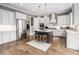 Modern kitchen features stainless steel appliances, white cabinets, a center island, and hardwood floors at 3039 Malbec Vly, Acworth, GA 30101