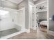 Modern bathroom with glass shower, white subway tile, gray flooring, and access to the main bedroom at 3039 Malbec Vly, Acworth, GA 30101