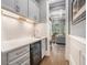 A sleek wet bar features a marble countertop, wine fridge, and drawers, all conveniently located adjacent to the living space at 3039 Malbec Vly, Acworth, GA 30101