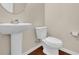 Powder room with white pedestal sink, toilet, and hardwood floors at 679 Barley Hill Ln, Sugar Hill, GA 30518
