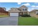 Charming two-story home with stone accents, well-manicured lawn, and a two car garage at 679 Barley Hill Ln, Sugar Hill, GA 30518