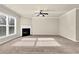 Spacious living room with fireplace, large window, and plush carpeting at 679 Barley Hill Ln, Sugar Hill, GA 30518