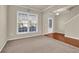Inviting living room with large window, neutral walls, and plush carpeting at 679 Barley Hill Ln, Sugar Hill, GA 30518