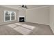 Spacious living room with fireplace, large window, and plush carpeting at 679 Barley Hill Ln, Sugar Hill, GA 30518