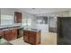 Open kitchen featuring an island, granite countertops, dark cabinets and stainless appliances at 5011 Wewatta Sw St, Atlanta, GA 30331