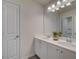 Bathroom with double sinks, white cabinets, large mirror and modern lighting at 597 River Gardens Dr, Atlanta, GA 30354
