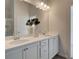 Bathroom with double sinks, white cabinets, quartz counters, and modern lighting at 597 River Gardens Dr, Atlanta, GA 30354
