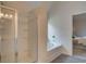 Modern bathroom featuring glass shower, soaking tub, and neutral color palette at 597 River Gardens Dr, Atlanta, GA 30354