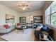 Living room featuring neutral walls, modern furnishings, ceiling fan, and large windows with natural light at 597 River Gardens Dr, Atlanta, GA 30354