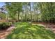 Well-manicured backyard with lush green lawn and mature trees, enclosed by a wooden fence at 12370 Preserve Ln, Johns Creek, GA 30005