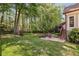 Large backyard featuring a patio area with comfortable chairs and a lush green lawn at 12370 Preserve Ln, Johns Creek, GA 30005
