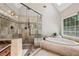 This bathroom has a glass enclosed shower with a soaking tub underneath a window at 12370 Preserve Ln, Johns Creek, GA 30005