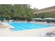 A sparkling, large community pool surrounded by lounge chairs and shaded umbrellas offers residents a relaxing retreat at 12370 Preserve Ln, Johns Creek, GA 30005