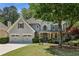 Charming two-story home with a well-manicured lawn, covered porch, and attached two-car garage at 12370 Preserve Ln, Johns Creek, GA 30005