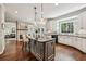 Spacious kitchen featuring an island, granite countertops, white cabinets, and stainless steel appliances at 12370 Preserve Ln, Johns Creek, GA 30005