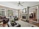 Comfortable living room with stone fireplace, plush seating, large windows, and access to the kitchen at 12370 Preserve Ln, Johns Creek, GA 30005